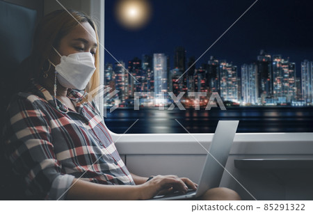 Businesswoman wearing a mask and working on laptop on a train,Big data analytics and business intelligence with chart and graph icons, Team success, HR Human, Business success and teamwork concept. 85291322