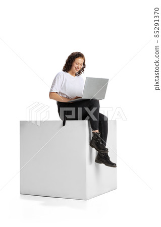 Full-length portrait of young girl working on laptop, having online conference isolated over white background 85291370