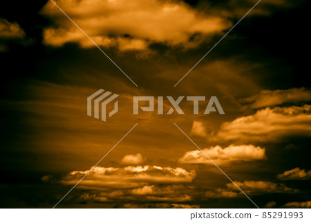Black orange dramatic fiery sky with clouds and yellow sunlight at sunset at night dusk before bad weather storm, fantastic scary anomalous natural abstract background in horror style 85291993