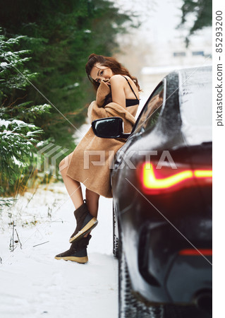 Healthy woman in lingerie and fur coat leaning to a car in winter forest Healthy woman in lingerie and fur coat leaning to a car in winter forest 85293200