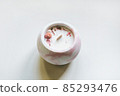 Ecological and vegan handmade candle on a white background with dry flowers in a glass made of concrete. Soy or coconut candle with a wooden wick. 85293476