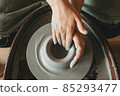 Female ceramics maker or potter working with pottery wheel in workshop. Creative people and handcraft pottery class concept. 85293477