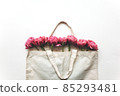 Bouquet of pink tulips in a canvas bag on a white background. 85293481