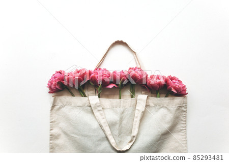 Bouquet of pink tulips in a canvas bag on a white background. Bouquet of pink tulips in a canvas bag on a white background. 85293481