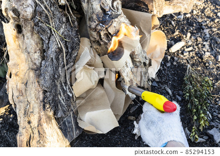 lighting fire with paper and butane torch outdoors lighting fire with paper and butane torch outdoors 85294153