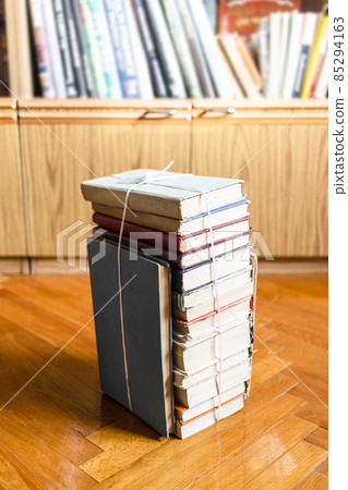 stack of old book tied with twine on wooden floor 85294163