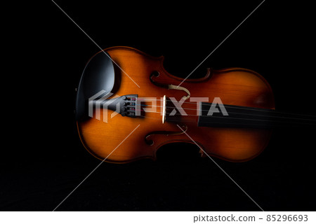 Part of the violin on a dark background. Part of the violin on a dark background. 85296693