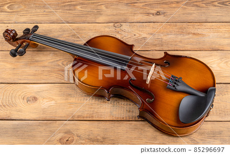 Top view of a violin lying on a wooden table. 85296697