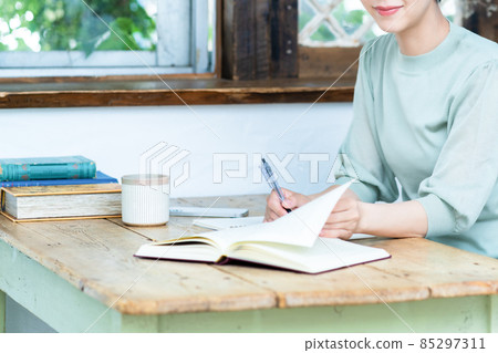 在窗邊的木桌旁學習的女性[零件切割] 85297311
