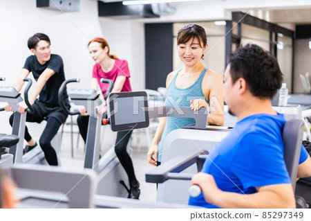 Middle-aged man receiving personal training at the gym 85297349