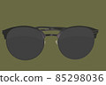 Sunglasses. Black sunglasses, close-up. Sun glasses. Old style sunglasses. Glasses with dark lenses. Vintage sun glasses on olive branch color background. Close up of worn out sunglasses. Horizonatal 85298036