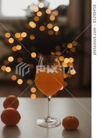 tangerine or orange juice with tangerines on the Christmas tree background  85298458