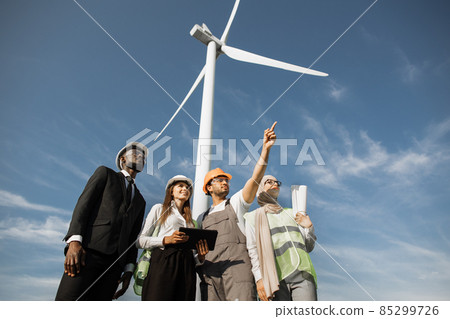 Multicultural partners examining work of wind turbines Multicultural partners examining work of wind turbines 85299726