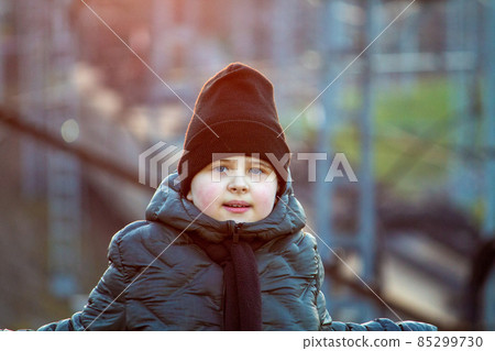 Looks into the distance. Autumn lighting, yellow autumn leaves all around. Autumn park forest. The boy is standing in the autumn park. Looks into the distance. Autumn lighting, yellow autumn leaves all around. Autumn park forest. The boy is standing in the autumn park. 85299730