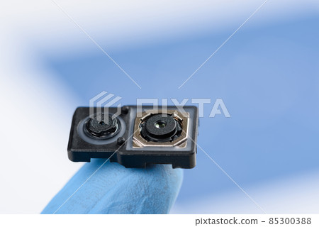 Smartphone dual camera system module on fingertip of hand in glove 85300388