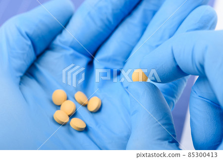 Scientist hold in hand small pill. New medical treatment or supplement laboratory research. Scientist hold in hand small pill. New medical treatment or supplement laboratory research. 85300413