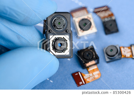 Smartphone dual sensor camera module in scientist hands, with other cell phone cameras Smartphone dual sensor camera module in scientist hands, with other cell phone cameras 85300426