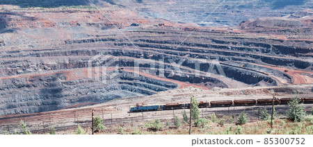 Iron ore extraction in the quarry of the Mikhailovsky mining and processing plant, a train travels inside the quarry 85300752