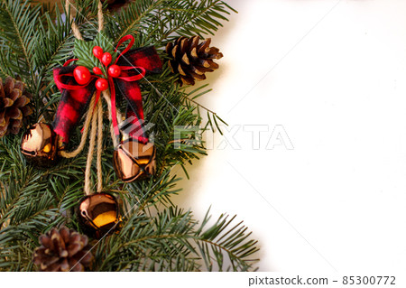Christmas background. Spruce branches with cones and bells Christmas background. Spruce branches with cones and bells 85300772