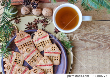 Christmas eve. Cookies in shape of houses and cup of tea Christmas eve. Cookies in shape of houses and cup of tea 85300774