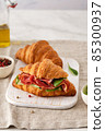 Fresh croissant or sandwich with cucumber, ham, Jamon, prosciutto, on wooden background. Morning breakfast concept. Healthy and fast food. 85300937