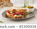 Sandwich with salami sausage and cucumber on marble background. 85300938