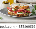 Sandwich with salami sausage and cucumber on marble background. 85300939
