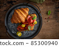 Fresh croissant or sandwich with cucumber, ham, Jamon, prosciutto, on wooden background. Morning breakfast concept. Healthy and fast food. 85300940