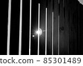 Close-up of a wooden gray fence on a sunny summer day. The sun shines through the fence 85301489