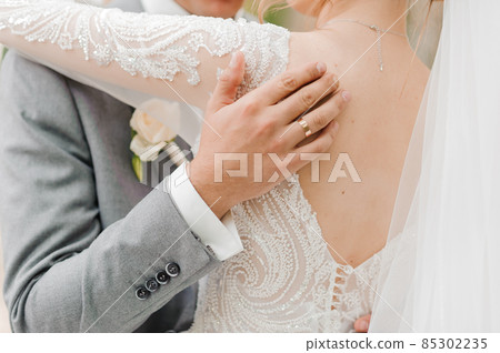 The groom holds the bride's hand. The guy holds the girl's hand The groom holds the bride's hand. The guy holds the girl's hand 85302235