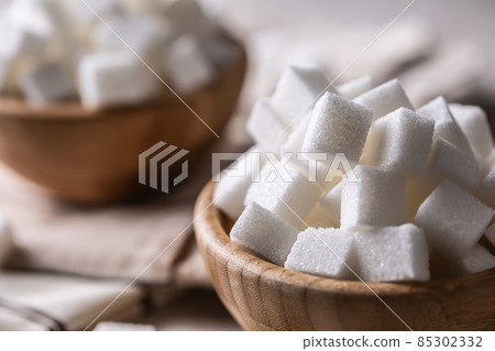 White sugar cubes in a wooden bowl on the table 85302332