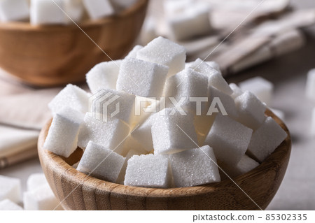 White sugar cubes in a wooden bowl on the table 85302335