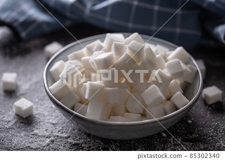 White sugar cubes in a blue bowl on the table White sugar cubes in a blue bowl on the table 85302340