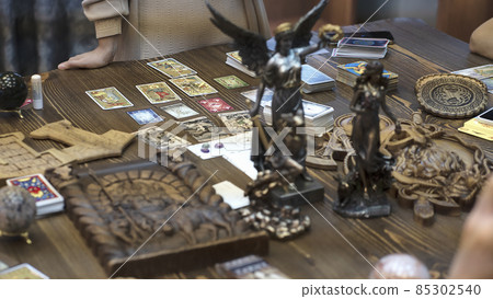 Tarot card reader arranges cards in a card spread. Fortune-telling concept Tarot card reader arranges cards in a card spread. Fortune-telling concept 85302540