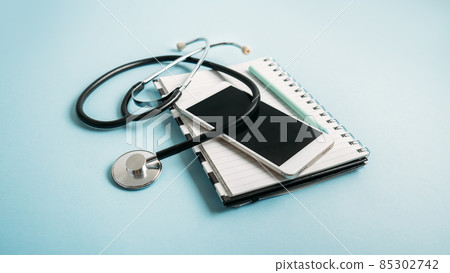 Telemedicine or telehealth virtual visit, video visit, remote doctor video chat consultation concept with smartphone, open notepad and stethoscope on blue background Telemedicine or telehealth virtual visit, video visit, remote doctor video chat consultation concept with smartphone, open notepad and stethoscope on blue background 85302742
