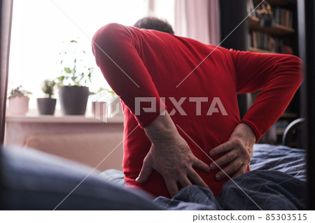 Senior man suffering from pain in back or reins at home 85303515