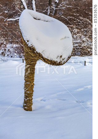 Garden installation in the form of a mushroom made of straw in the snow 85303676