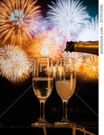 two champagne glasses against fireworks New Year's eve celebration two champagne glasses against fireworks New Year's eve celebration 85303986