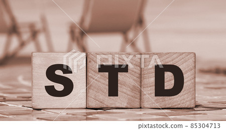 Wooden block form the word STD on elaxed ocean beach landscape background. Healthcare concept. Wooden block form the word STD on elaxed ocean beach landscape background. Healthcare concept. 85304713