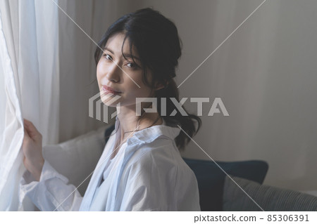 Portrait of a smiling woman by the window Portrait of a smiling woman by the window 85306391