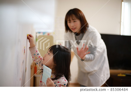 Girl putting a sticker on the wall 85306484