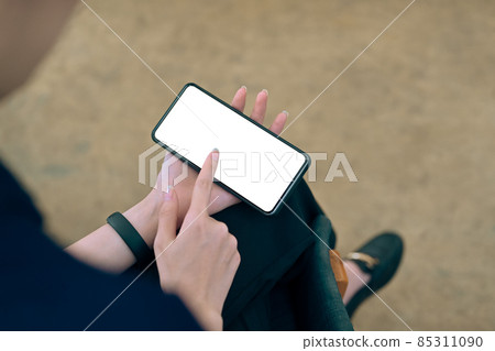 Close up view businesswoman holding smart phone and pointing on empty screen. 85311090