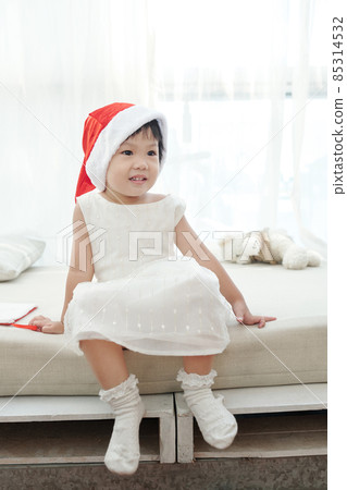 Adorable Girl Sitting on Bed 85314532