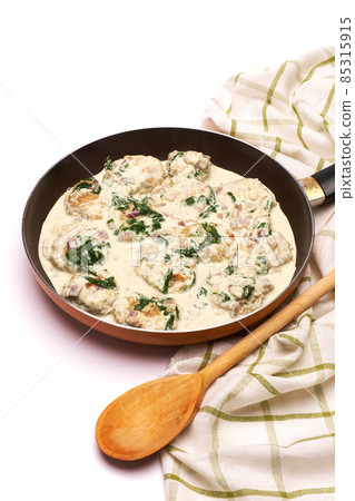 Delicious small meatballs with spinach in a creamy sauce in the frying pan Delicious small meatballs with spinach in a creamy sauce in the frying pan 85315915