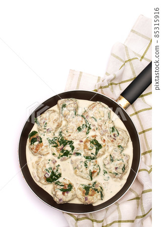 Delicious small meatballs with spinach in a creamy sauce in the frying pan Delicious small meatballs with spinach in a creamy sauce in the frying pan 85315916