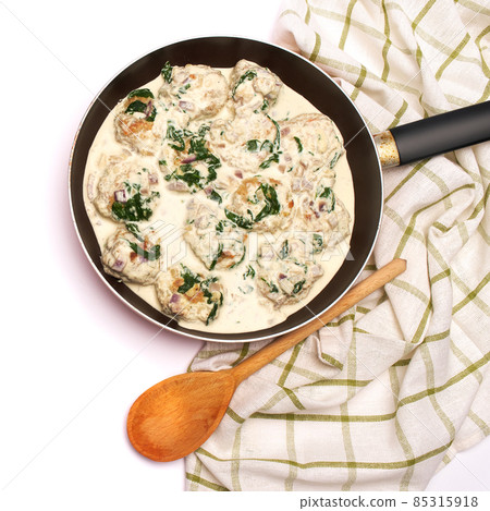 Delicious small meatballs with spinach in a creamy sauce in the frying pan 85315918