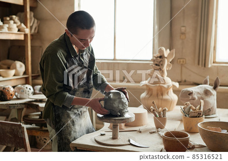 Young sculptor making form from the clay to make beautiful sculptures in workshop Young sculptor making form from the clay to make beautiful sculptures in workshop 85316521