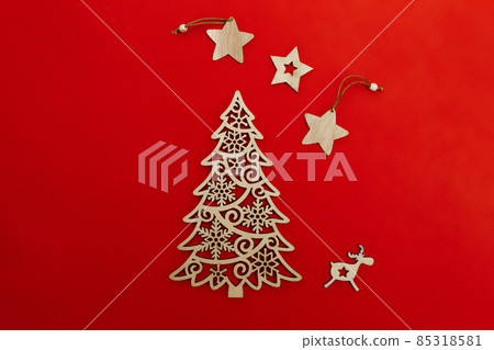 wooden decorative decoration of fir-tree, star and deer on red background wooden decorative decoration of fir-tree, star and deer on red background 85318581