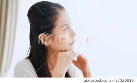 Senior woman worried at home Senior woman worried at home 85320019