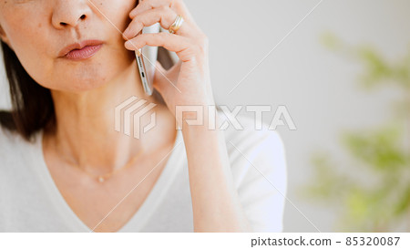 Senior woman making a phone call on her smartphone Senior woman making a phone call on her smartphone 85320087